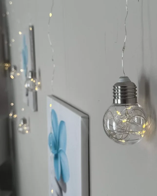 Warm fairy lights and soft floral artwork in the treatment room