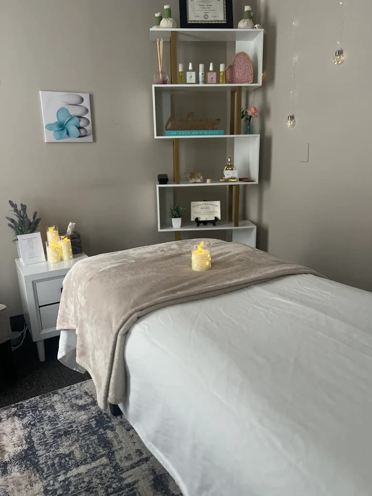 Cozy massage table with a soft throw, candle, and warm lighting